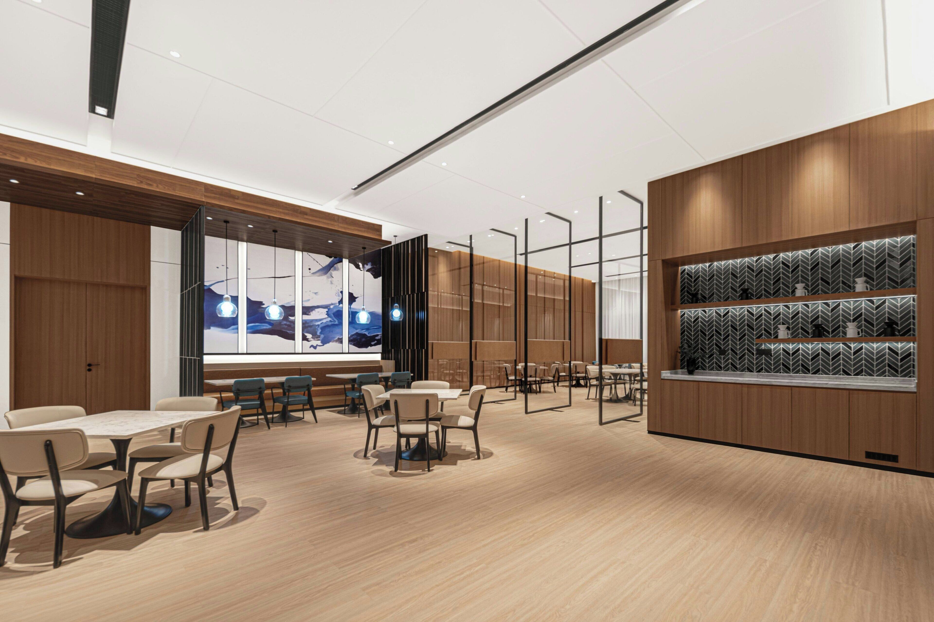 A modern dining area with wooden paneling, a large window with a cityscape view, and a patterned shelf.