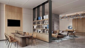 A modern interior with a central wooden desk, a built-in bookshelf, and a seating area with sofas and chairs. - Fairfield By Marriott Yinchuan Xingqing (Yinchuan)