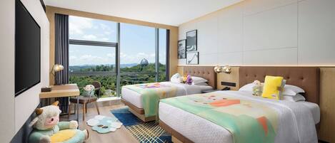 A hotel room with two beds, a desk, and a large window offering a view of the outdoors.