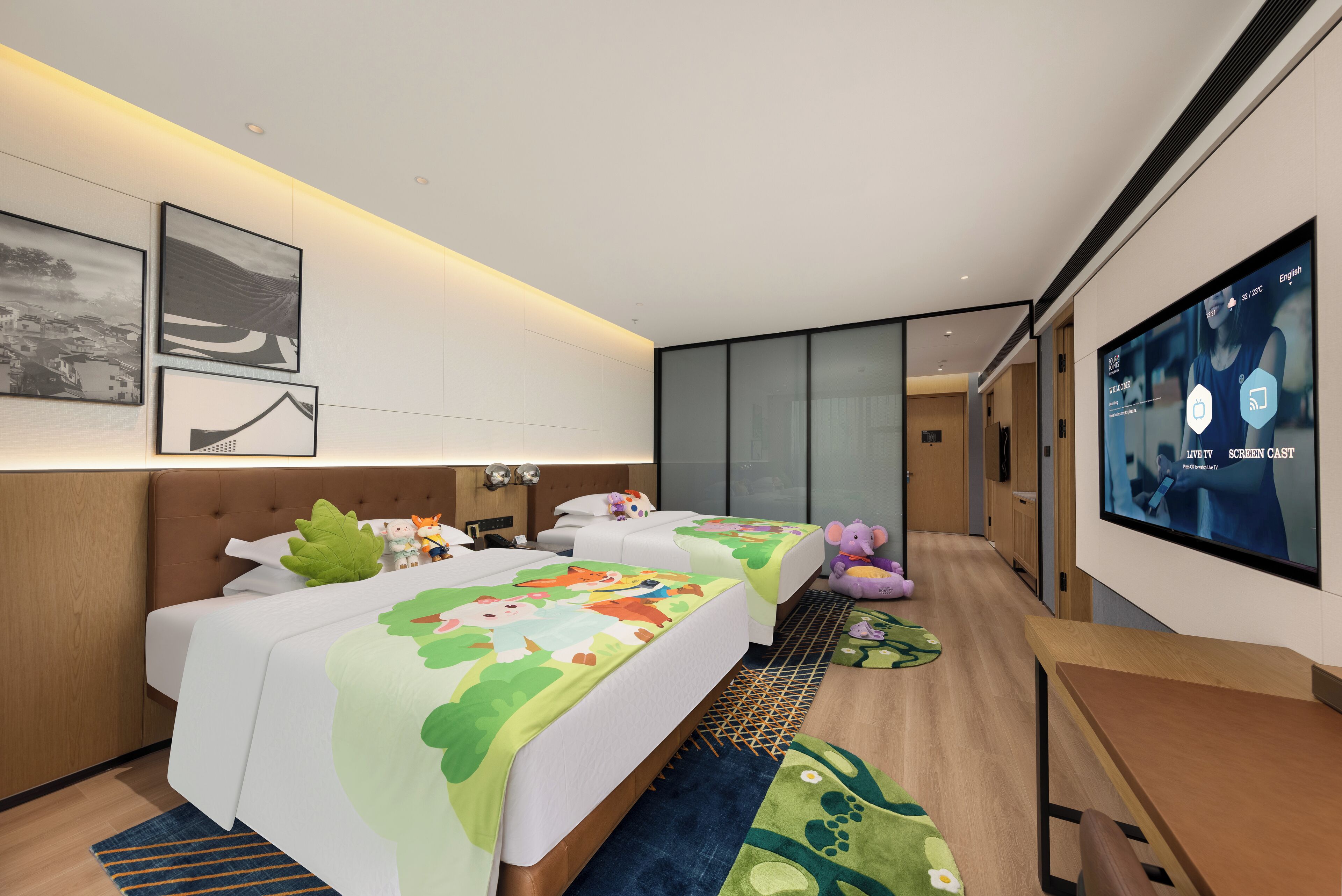 A hotel room with two beds, a TV, and a desk.