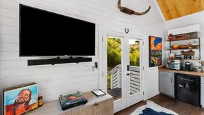 Une cuisine moderne dotée d’un grand téléviseur à écran plat, d’un meuble en bois et d’une décoration rustique comprenant une corne fixée au mur.
