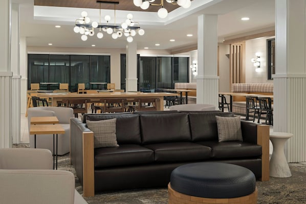 Ein modernes Interieur mit einer Ledersofa, Holztischen und einem Chandelier.