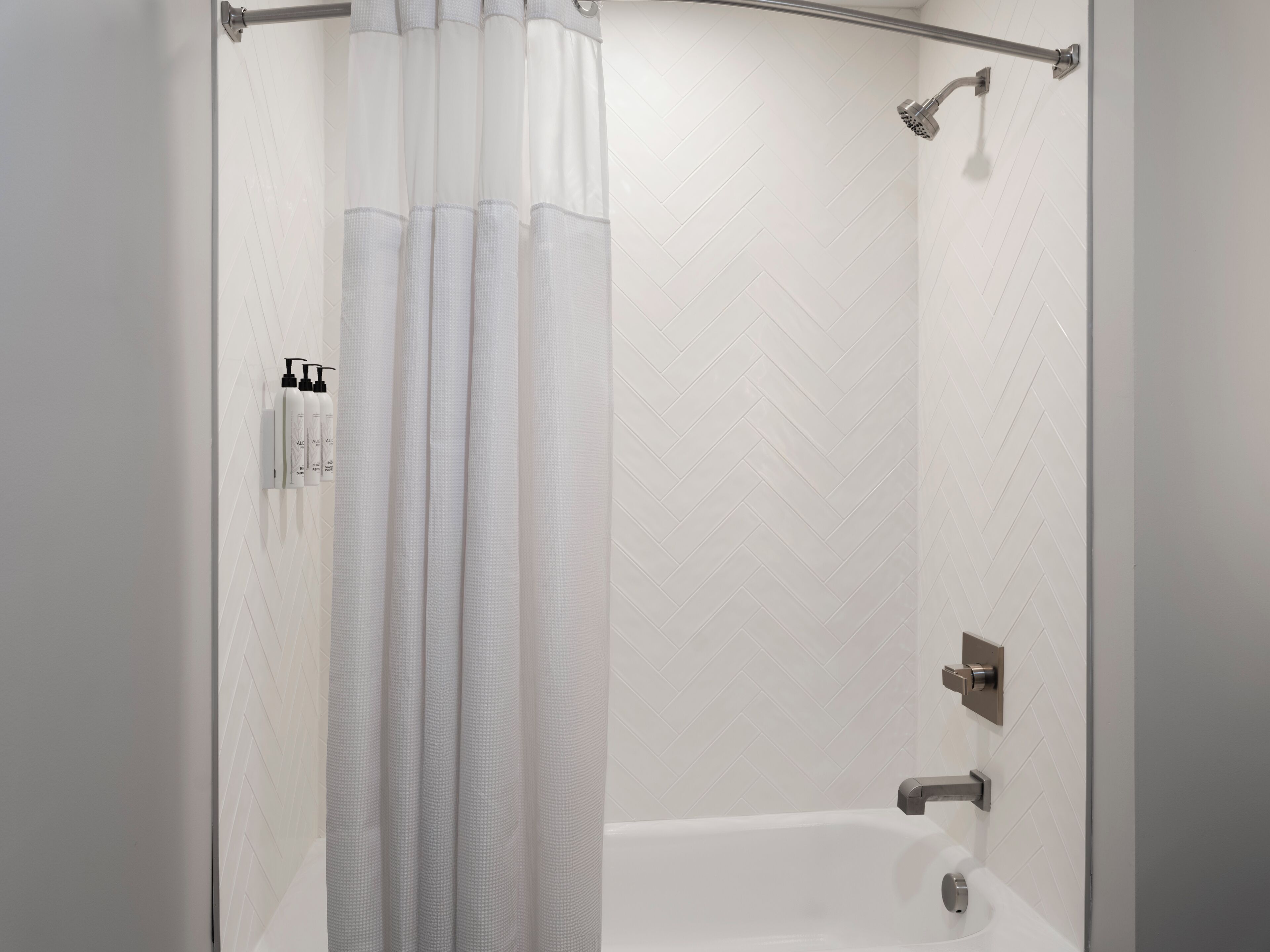Une douche moderne dotée d’un pommeau de douche à pluie, d’un pommeau de douche à main et d’un autre pommeau de douche à main.