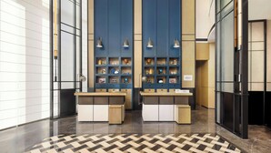 Un hall d’entrée moderne avec un comptoir d’enregistrement, des étagères bleues ornées d’objets décoratifs et un sol à motifs.