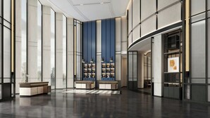 Un hall d’entrée spacieux, doté de hauts plafonds, de grandes fenêtres et d’un mobilier moderne.
