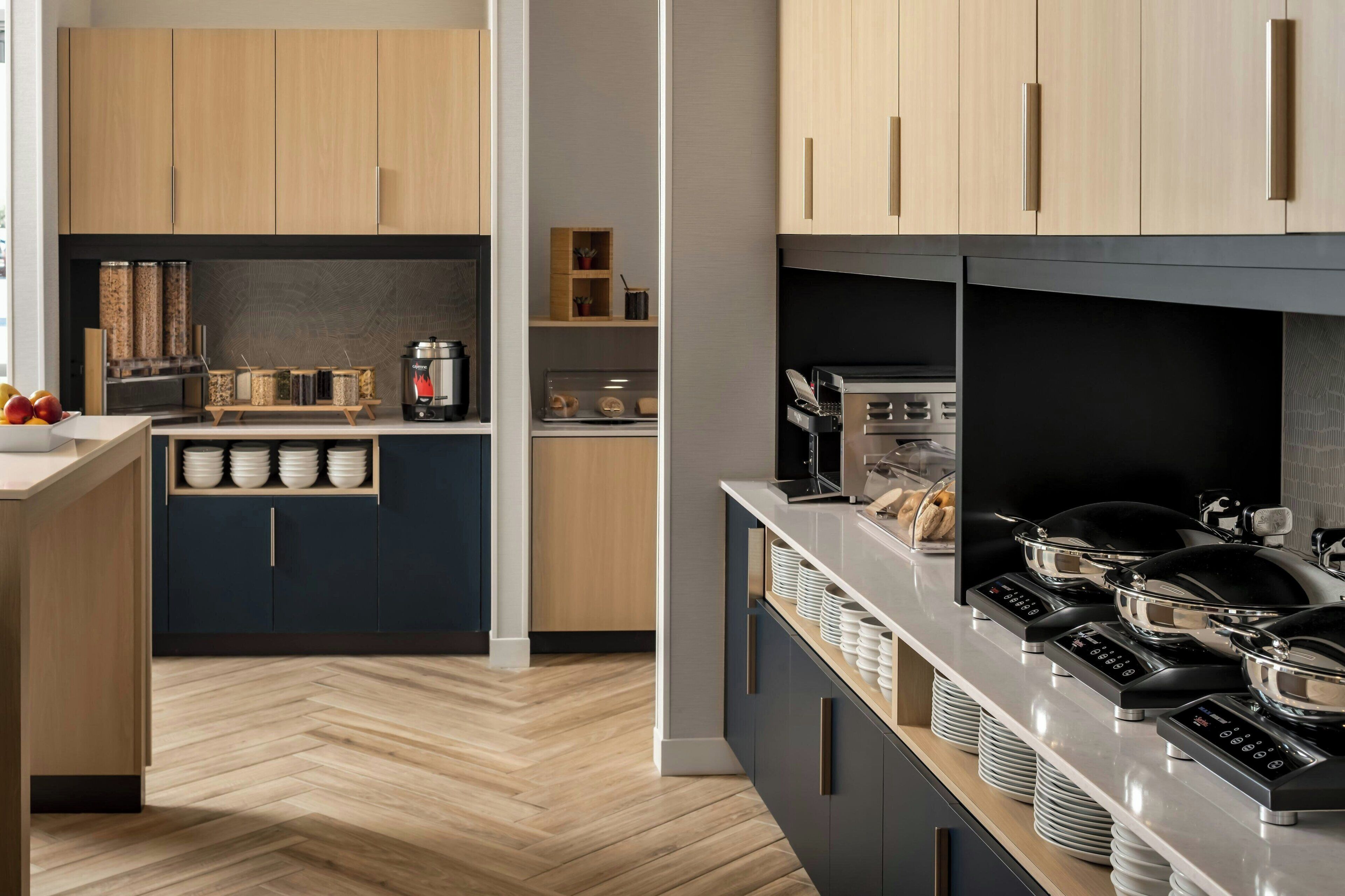 A modern kitchen with wooden cabinets, a herringbone floor, and a built-in stove.