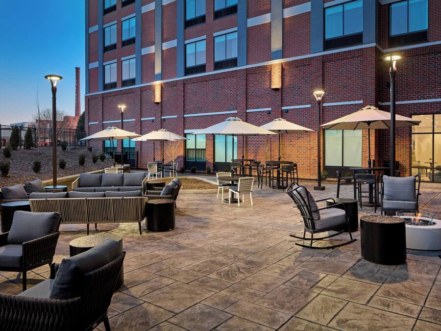 An outdoor patio with seating, umbrellas, and a fire pit.