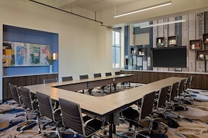 A conference room with a long table, chairs, and a large screen. - Springhill Suites By Marriott High Point Downtown (High Point)