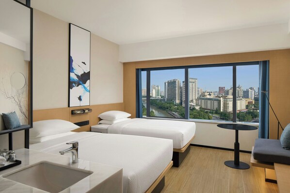 A hotel room with two beds, a sink, a small table, and a large window offering a city view. - Fairfield By Marriott Chengdu Tianfu Square (Chengdu)
