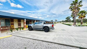 A silver pickup truck parked in front of a building with a brick facade and a blue awning.