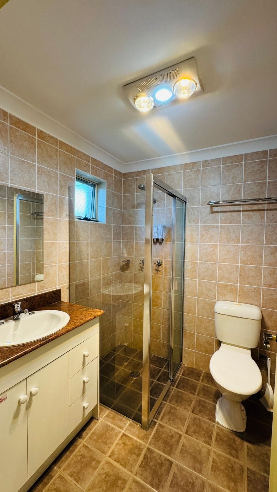 A bathroom with a shower, toilet, and sink.