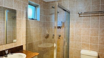 A bathroom with a shower, toilet, and sink.