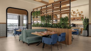 A modern dining area with a wooden partition, blue chairs, and a green sofa. - Four Points By Sheraton Kinshasa (Kinshasa)