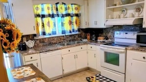 A kitchen with white cabinets, a granite countertop, a stove, and a microwave. - Beautiful 3-bedroom house with AC in Elizabeth City (Elizabeth City)