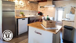 Une cuisine équipée d’un réfrigérateur en acier inoxydable, d’un lave-vaisselle, d’un plan de travail en bois et d’un évier.