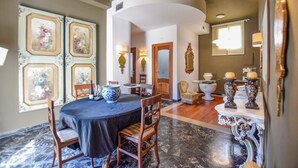 A dining area with a round table, chairs, and a chandelier.
