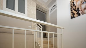 A staircase with white railings leading to an upper floor. - Cozy home in Solarino with WiFi (Solarino)