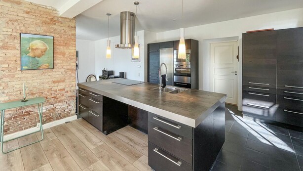 A modern kitchen with a large island, stainless steel appliances, and a brick accent wall. - 2 bedroom nice home in Harpelunde (Harpelunde)