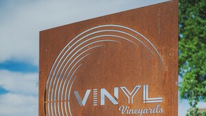 A rusty sign with "VINYL Vineyards" and "ENTRANCE" written on it. - Vinyl Vineyards  (Paso Robles)