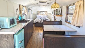A compact kitchen with a microwave, sink, and wooden cabinets. - Vinyl Vineyards (Paso Robles)