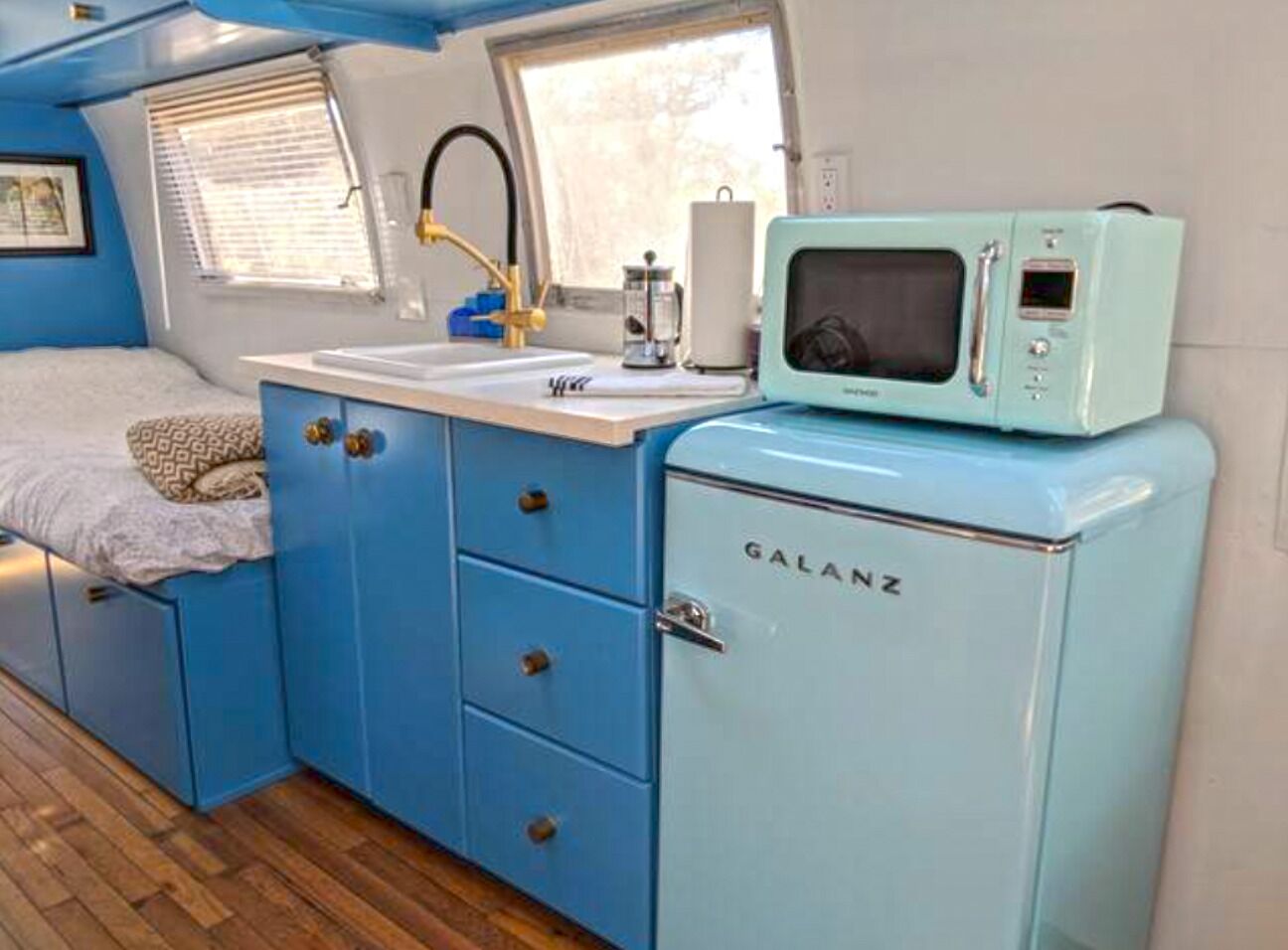 A compact kitchenette with a blue Galanz refrigerator, a sink, and a microwave.