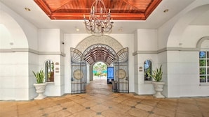 A spacious lobby with a tiled floor, a wooden ceiling, and a chandelier. - Beautiful First-floor, End Unit, Coach Home in Fiddler's Creek, Naples, FL (Naples)