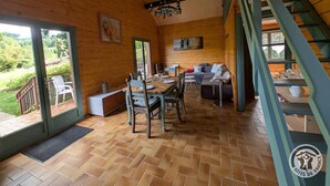 Un intérieur en bois comprenant un coin repas, un canapé et un escalier.