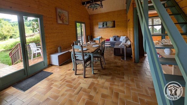 Un intérieur en bois comprenant un coin repas, un canapé et un escalier.