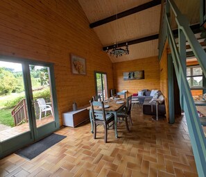 A wooden interior with a dining area, sofa, and staircase. - L'écho du temps - MEAUX LA MONTAGNE (MEAUX LA MONTAGNE)