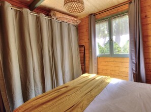 A wooden room with a bed, curtains, and a window. - L'écho du temps - MEAUX LA MONTAGNE (MEAUX LA MONTAGNE)