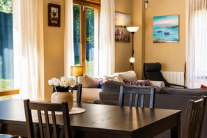 A living room with a sofa, a dining table, and a lamp.