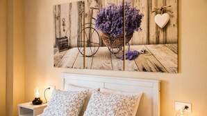 A bedroom with a bed, two nightstands, a wall-mounted lamp, and a painting of a bicycle basket with flowers. - Villa Playa de Barro with garden - Llanes (Llanes)