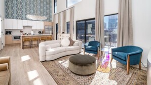 A modern apartment with a kitchen, living area, and large windows offering city views.