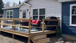 A house with a wooden deck, a barbecue grill, and a covered outdoor seating area. - The Salsbury Star- large family home, downtown location, pet friendly (Cody)