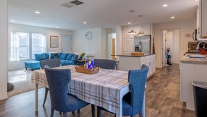 A modern kitchen with a central island, a dining area with a table and chairs, and a living room with a sofa and a coffee table. - The Salsbury Star- large family home, downtown location, pet friendly (Cody)