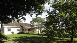 A house with a sloped roof, a front porch, and a well-maintained lawn. - Bed & Breakfast La Planche Pinçon (Teloché)
