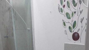 A bathroom with a toilet, bidet, sink, and a glass shower enclosure. - APTO Granja Vianna Brand New (Cotia)