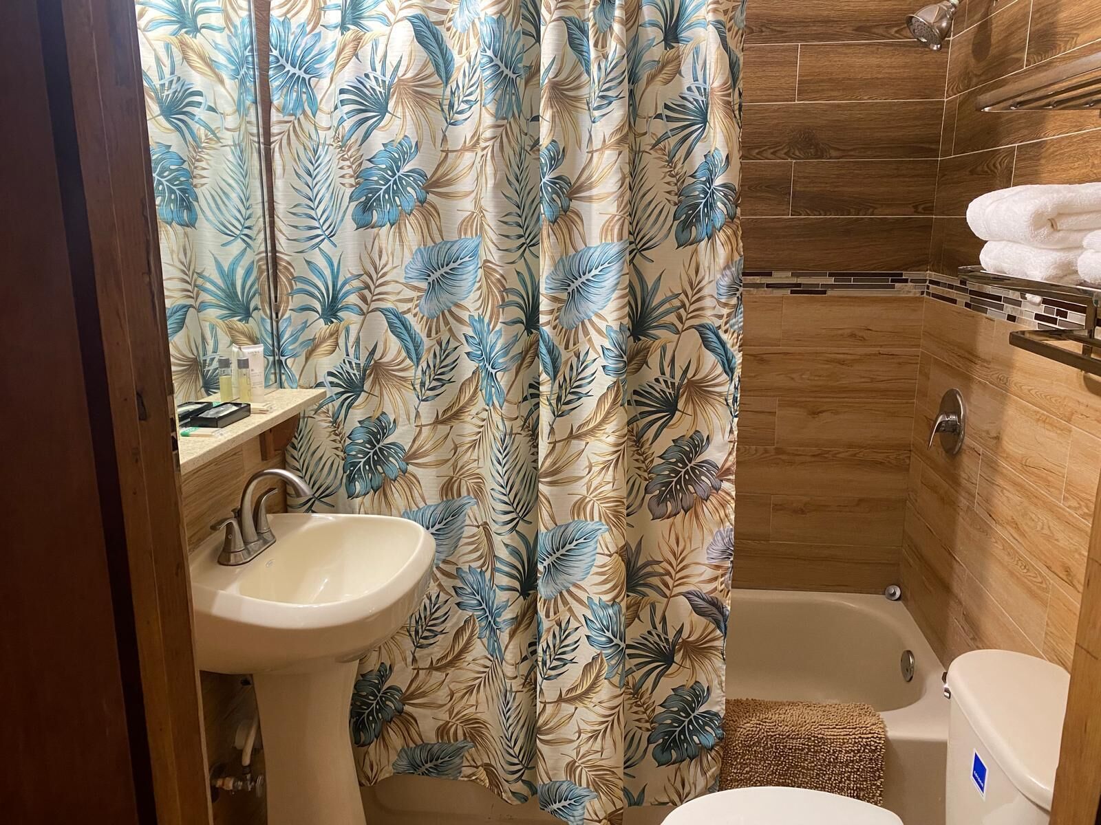 A bathroom with a shower, toilet, and sink.