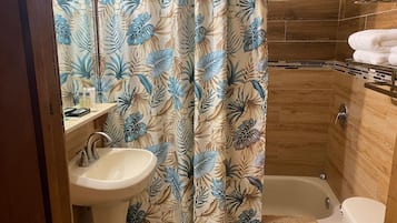 A bathroom with a shower, toilet, and sink.