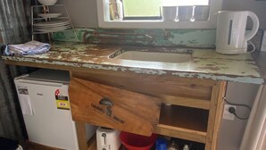 A kitchen with a wooden countertop, a microwave, a refrigerator, and a window with a view. - Weka cabin, great views (Wainui)