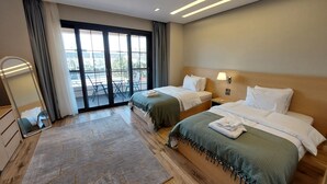 A hotel room with two beds, a large window with a view, a mirror, and a wooden floor. - Mirage Taiaa Hotel Apartments (New Cairo)