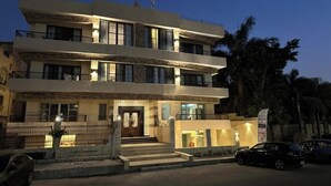A modern multi-story hotel with a well-lit entrance and a visible reception area. - Mirage Taiaa Hotel Apartments (New Cairo)
