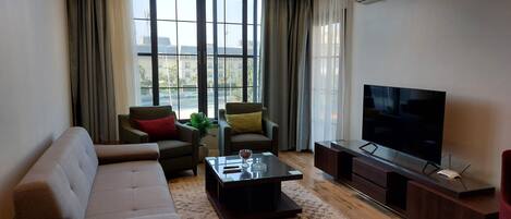 Departamento de lujo, 2 habitaciones, balcón, vista al jardín | Área de sala de estar | Televisión LCD de 55 pulgadas con canales vía satélite y Netflix