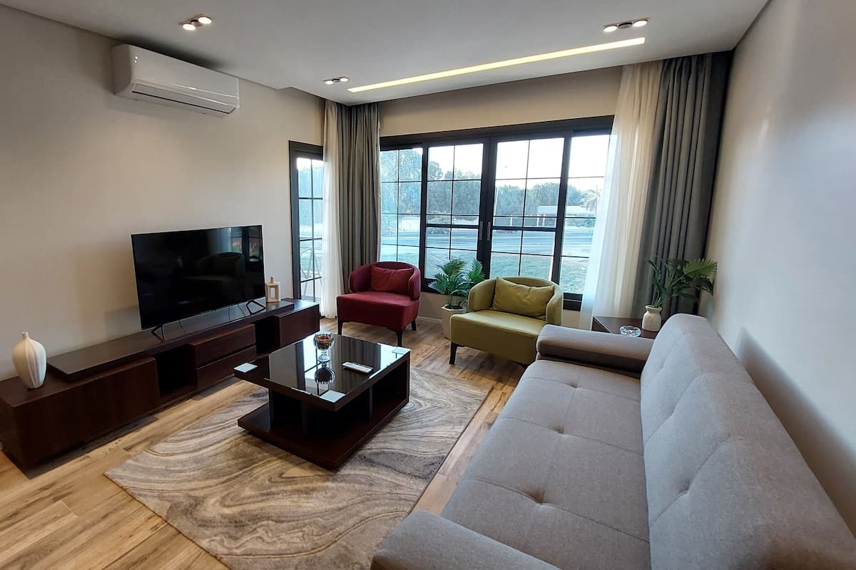 Appartamento Luxury, 1 camera da letto, balcone, vista giardino | Area soggiorno | TV LCD 55 pollici con canali satellitari, Netflix, servizi in streaming
