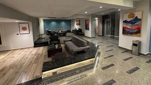 A spacious lobby with a modern reception desk, seating area, and artwork on the walls. - Mirage Taiaa Hotel Apartments (New Cairo)