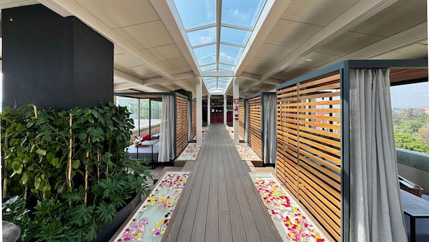 A corridor with a wooden floor, glass ceiling, and a view of the city. - Hot Elite | Love Hotel | Solo Adultos (Mexico City)