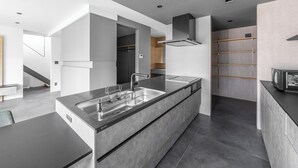 A modern kitchen with a large island, built-in appliances, and a sleek design. - S suzukou (Asahikawa)
