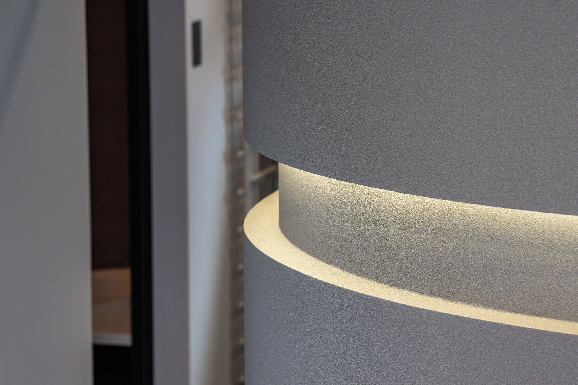 A close-up of a textured wall with a curved, illuminated edge.