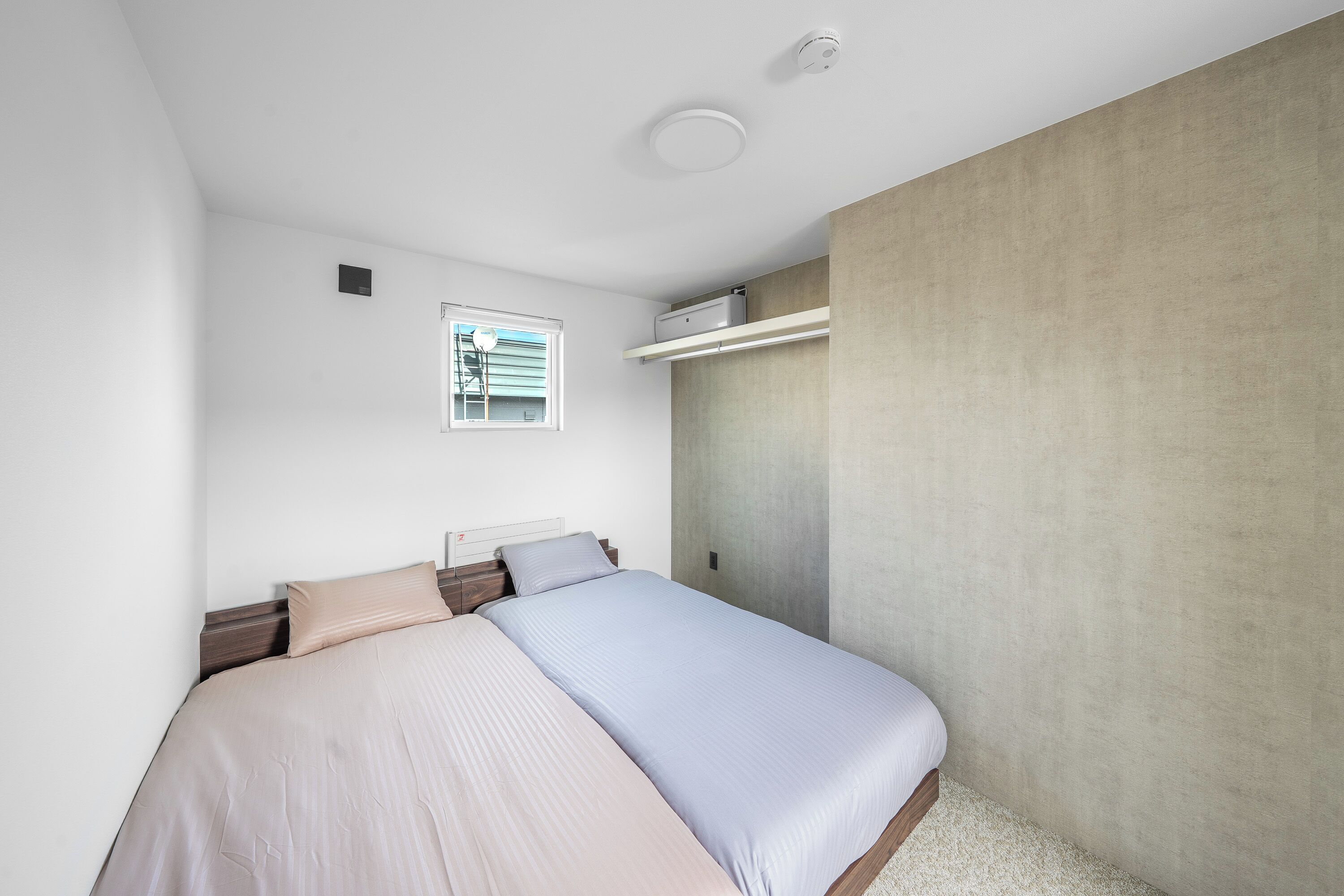 A modern bedroom with a bed, a window, a wall-mounted shelf, and a ceiling light.