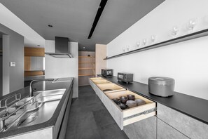 A modern kitchen with a built-in sink, a microwave, and a coffee maker on the countertop. - S suzukou (Asahikawa)